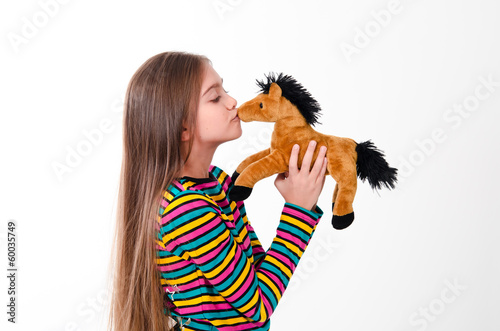 Photo: girl kisses a toy horse girl kisses a toy horse