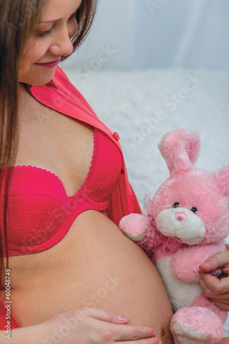 Photo: Pregnant woman in red underwear holding toy Pregnant woman in red underwear holding toy
