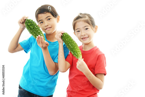 Photo: ニガウリを持つ笑顔の女の子 ニガウリを持つ笑顔の女の子