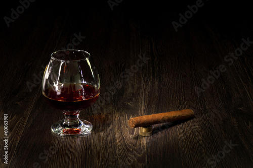Photo: Cognac, cigar and an old book nearby Cognac, cigar and an old book nearby
