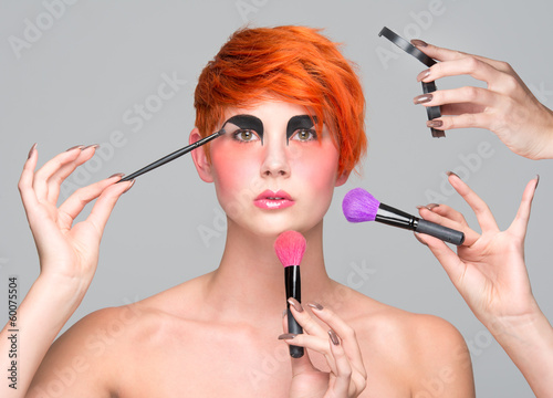 Photo: a young red-haired girl putting on makeup a young red-haired girl putting on makeup
