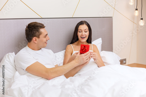 Photo: man giving woman little red gift box man giving woman little red gift box