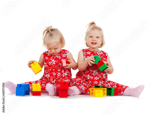Photo: two twin girls in red dresses playing with blocks two twin girls in red dresses playing with blocks