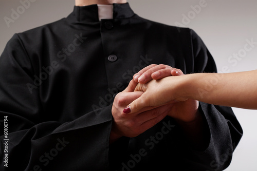 Photo: Priest holding believer hand Priest holding believer hand