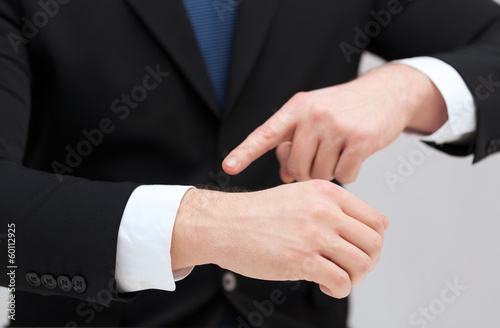 Photo: businessman pointing to something at his hand businessman pointing to something at his hand