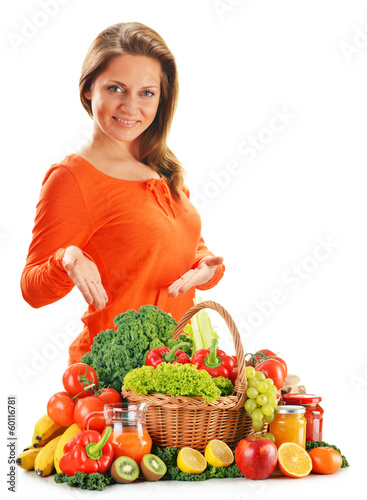 Photo: Young woman with variety of organic vegetables isolated on white Young woman with variety of organic vegetables isolated on white