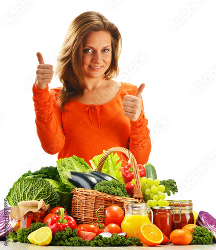 Photo: Young woman with variety of organic vegetables isolated on white Young woman with variety of organic vegetables isolated on white