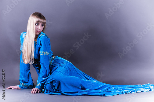 Photo: beautiful woman lying on the floor in a blue dress beautiful woman lying on the floor in a blue dress