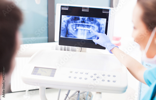 Photo: Dentist explaining x ray picture to patient Dentist explaining x ray picture to patient