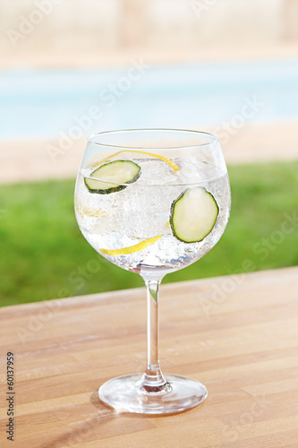 Photo: Cucumber gin and tonic cocktail by a pool outdoors Cucumber gin and tonic cocktail by a pool outdoors