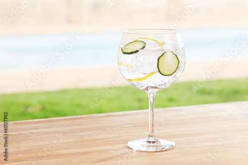 Photo: Cucumber gin and tonic cocktail by a pool outdoors Cucumber gin and tonic cocktail by a pool outdoors