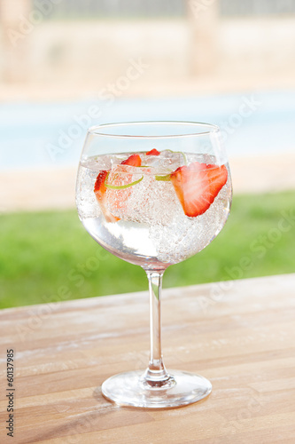 Photo: Strawberry gin and tonic cocktail by a pool outdoors Strawberry gin and tonic cocktail by a pool outdoors