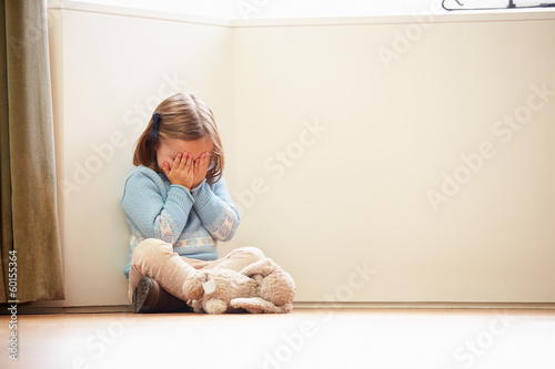 Photo: Unhappy Child Sitting On Floor In Corner At Home Unhappy Child Sitting On Floor In Corner At Home