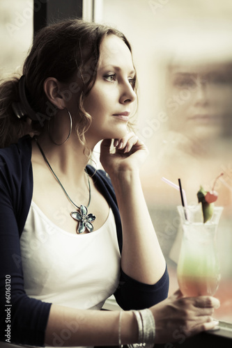 Photo: Sad beautiful woman looking out window Sad beautiful woman looking out window