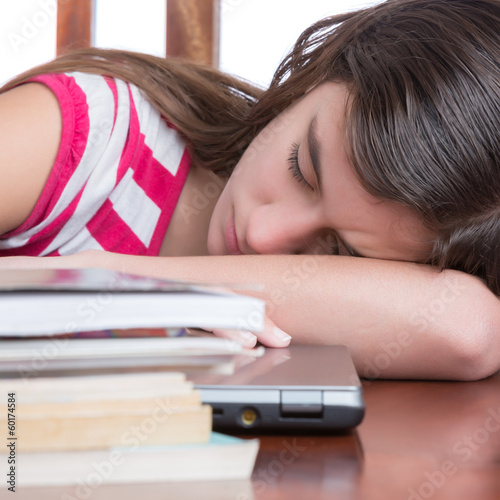 Photo: Tired schoolgirl sleeping over her laptop computer Tired schoolgirl sleeping over her laptop computer