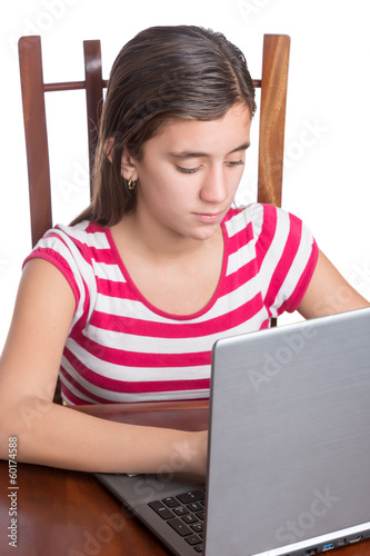 Photo: Teenager typing on her laptop isolated on white Teenager typing on her laptop isolated on white