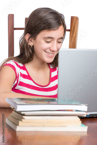 Photo: Teenager doing homework on her laptop isolated on white Teenager doing homework on her laptop isolated on white