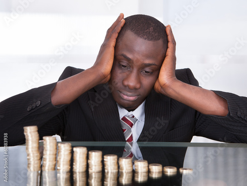 Photo: Worried Businessman Looking At Coins Worried Businessman Looking At Coins