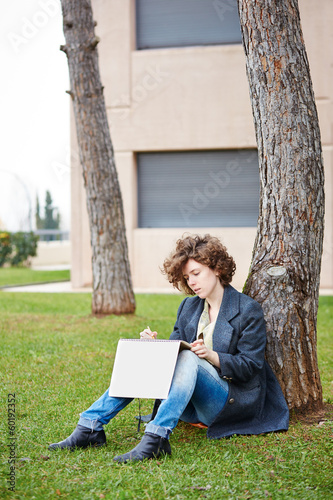 Photo: Female redhead art student drawing outdoors Female redhead art student drawing outdoors