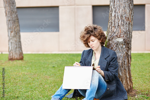 Photo: Female redhead art student drawing outdoors Female redhead art student drawing outdoors