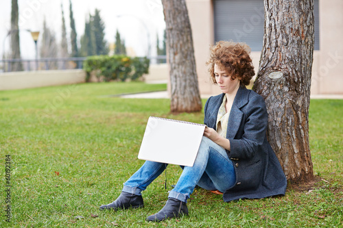 Photo: Female redhead art student drawing outdoors Female redhead art student drawing outdoors