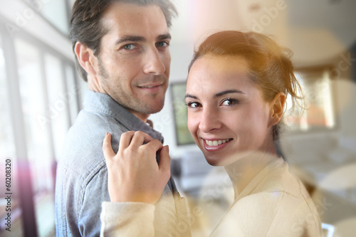 Photo: Portrait of smiling couple relaxing at home Portrait of smiling couple relaxing at home
