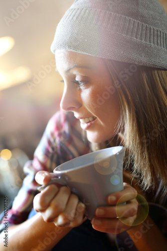 Photo: Trendy girl at home having hot drink Trendy girl at home having hot drink