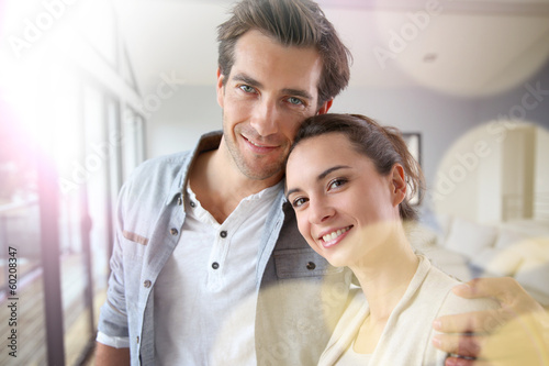 Photo: Portrait of smiling couple relaxing at home Portrait of smiling couple relaxing at home