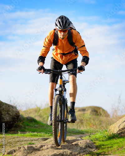 Photo: Cyclist Riding the Bike on the Beautiful Mountain Trail Cyclist Riding the Bike on the Beautiful Mountain Trail
