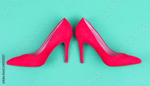 Photo: Beautiful red female shoes, on green background Beautiful red female shoes, on green background