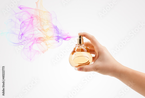 Photo: woman hands spraying perfume woman hands spraying perfume
