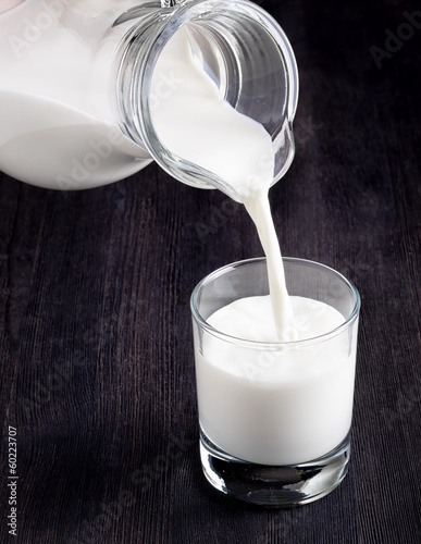 Photo: Milk pouring into a glass on black board Milk pouring into a glass on black board