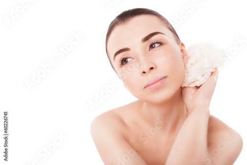Photo: Young beautiful woman relaxing with flower at spa Young beautiful woman relaxing with flower at spa