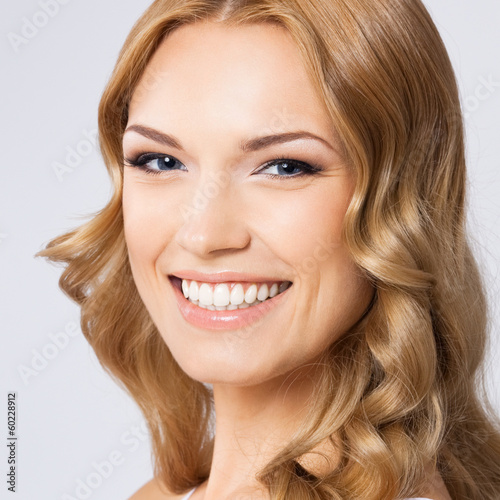 Photo: Young cheerful smiling woman, on gray Young cheerful smiling woman, on gray