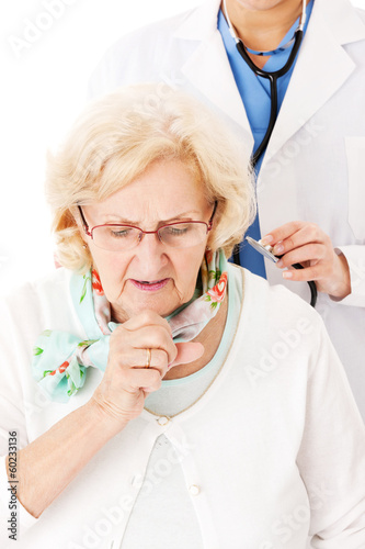 Photo: Senior Woman Coughing While Doctor Examining Her Senior Woman Coughing While Doctor Examining Her