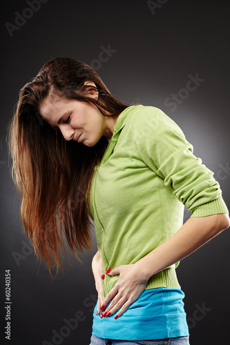 Photo: Young woman having a severe abdominal pain Young woman having a severe abdominal pain