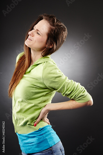 Photo: Young woman having a severe lumbar pain Young woman having a severe lumbar pain
