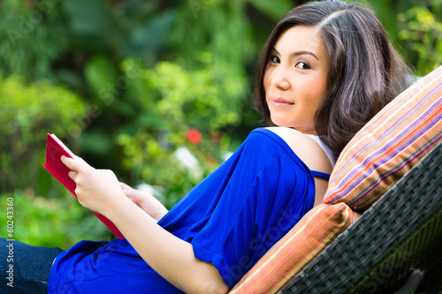 Photo: Young Asian woman at home in garden Young Asian woman at home in garden