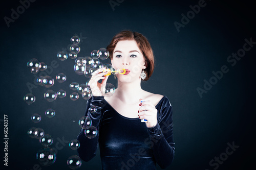Photo: Young woman making soap bubbles Young woman making soap bubbles