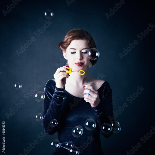 Photo: Young woman making soap bubbles Young woman making soap bubbles