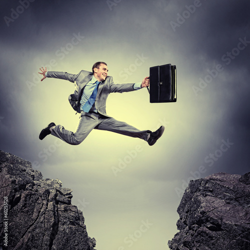 Photo: Businessman jumping over gap Businessman jumping over gap