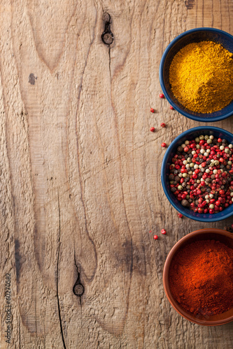 Photo: spices background: pink and black pepper, paprika powder, curry spices background: pink and black pepper, paprika powder, curry