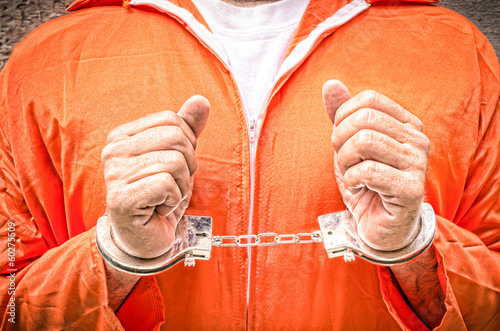 Photo: Handcuffed Hands - Guantanamo prison orange clothes Handcuffed Hands - Guantanamo prison orange clothes