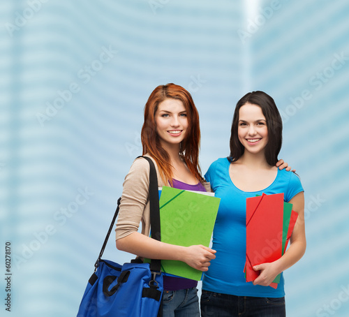 Photo: two smiling students with bag and folders two smiling students with bag and folders