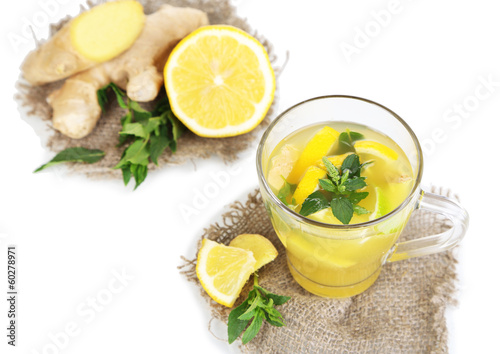 Photo: Cup of tea with ginger on sackcloth isolated on white Cup of tea with ginger on sackcloth isolated on white