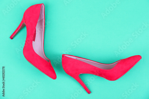 Photo: Beautiful red female shoes, on green background Beautiful red female shoes, on green background