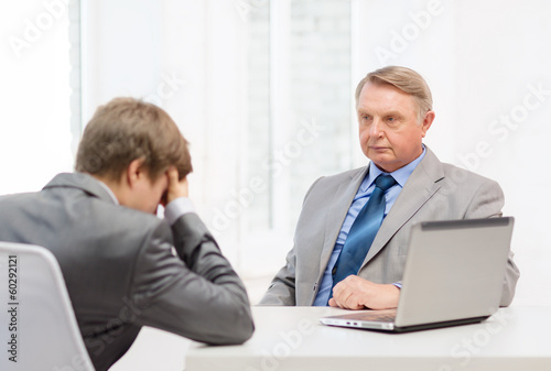 Photo: older man and young man having argument in office older man and young man having argument in office