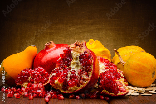 Photo: pumpkin and pomegranate on fabric background pumpkin and pomegranate on fabric background