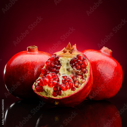 Photo: red pomegranate fruits on a dark background red pomegranate fruits on a dark background