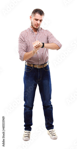 Photo: young man looking at watch over white background young man looking at watch over white background